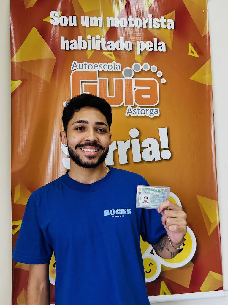 Aluno da Autoescola Guia sorrindo segurando a CNH recém-emitida